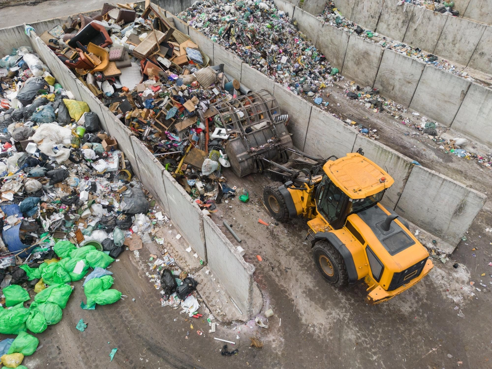 Heavy machinery sorting mixed recyclable waste at recycling center used by Dump Pro LA in Los Angeles